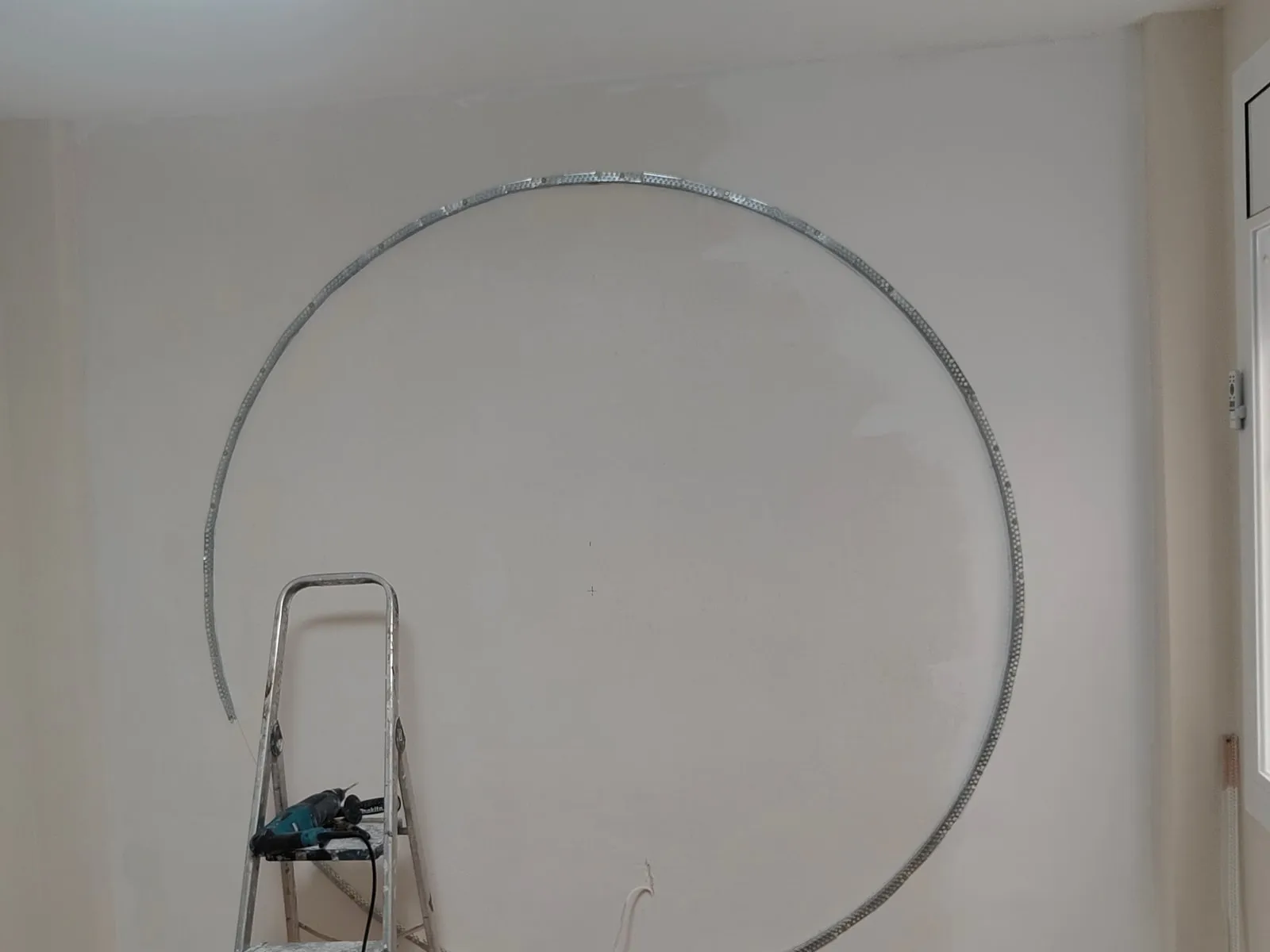 Dormitorio durante la obra, con el aro metálico de la luna ya fijado en la pared